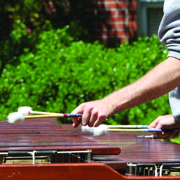 Student playing percussion instrument outdoors
