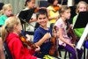 Kids smiling and practicing violin
